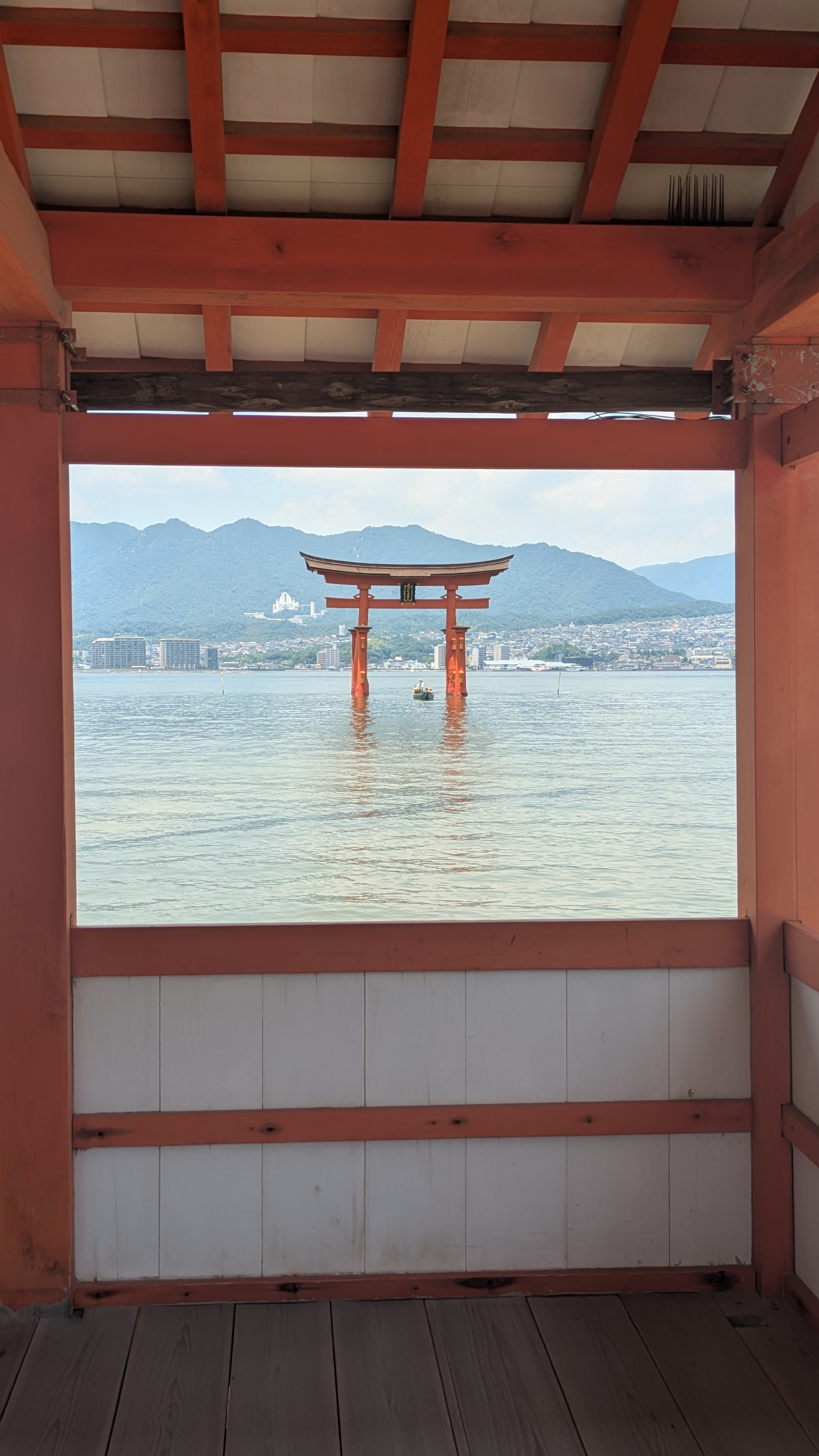Le torii flottant d'Itsukushima vu à travers une ouverture du sanctuaire