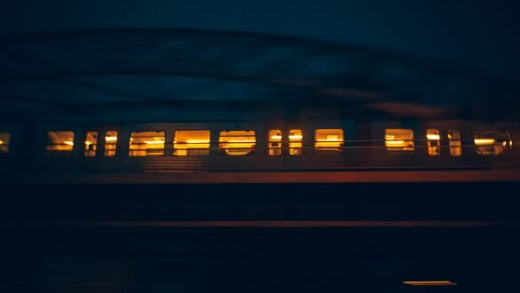 Train de nuit européen filant dans la nuit, fenêtres éclairées