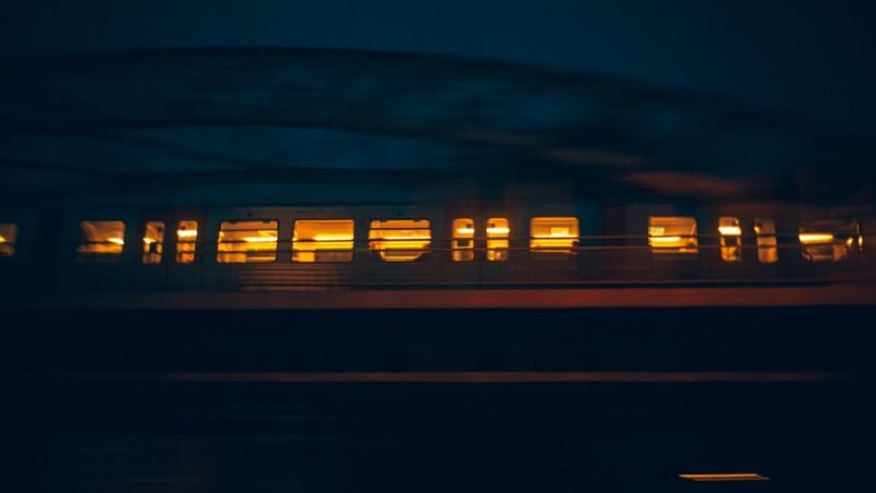 Train de nuit européen filant dans la nuit, fenêtres éclairées