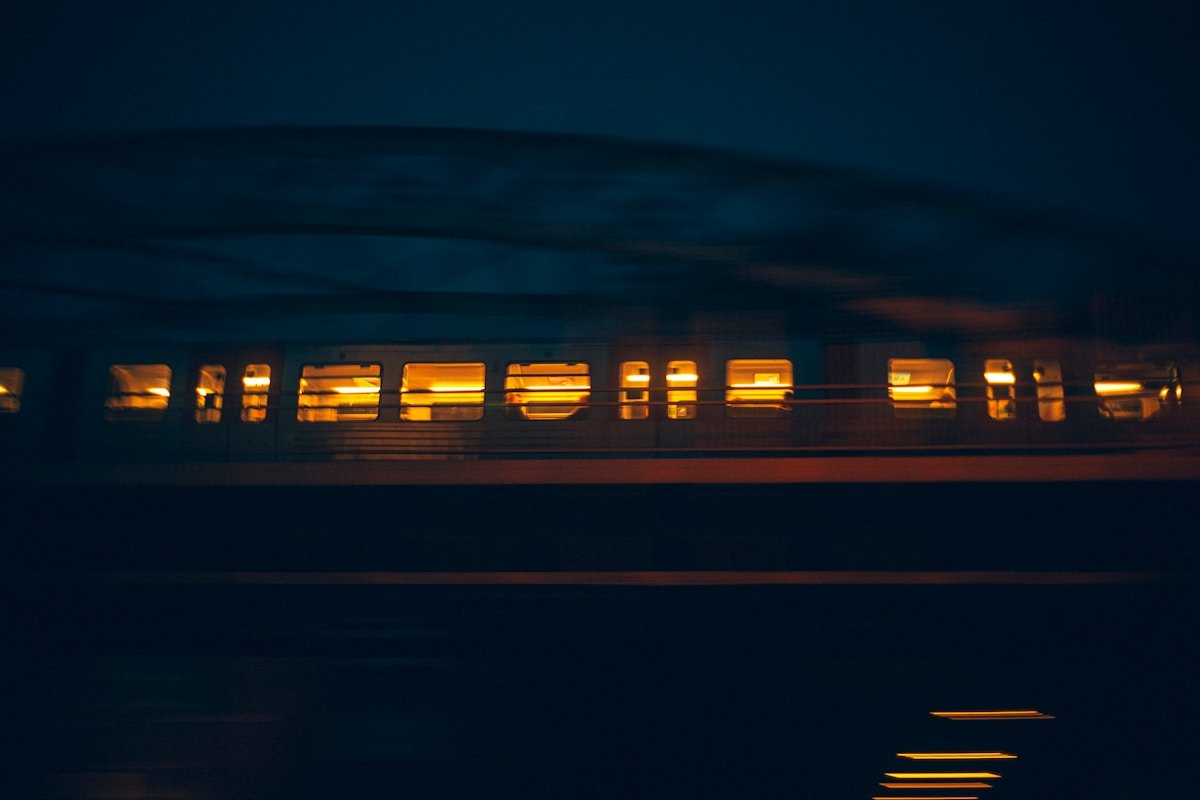 Train de nuit européen filant dans la nuit, fenêtres éclairées