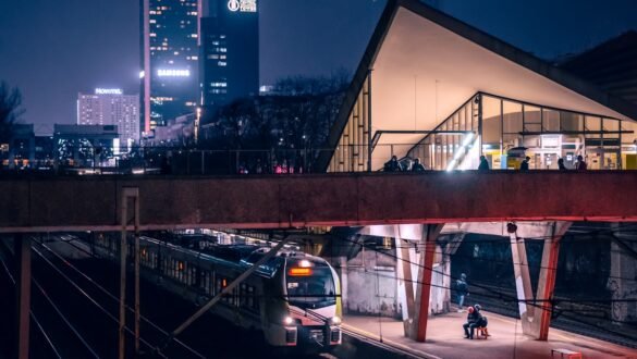 Train arrivant en gare européenne de nuit, éclairage urbain