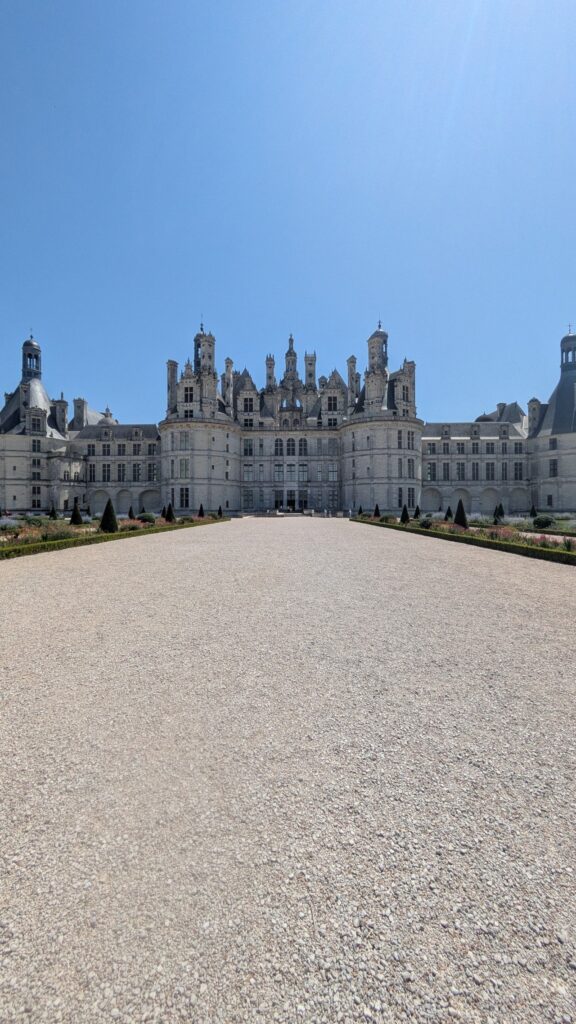 Longue allée de gravier menant à la façade du château de Chambord