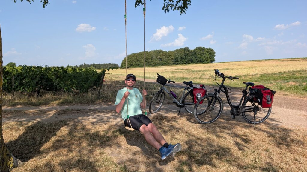 Pause sur une balançoire au bord des vignes pendant la Loire à vélo, vélos avec sacoches en arrière-plan